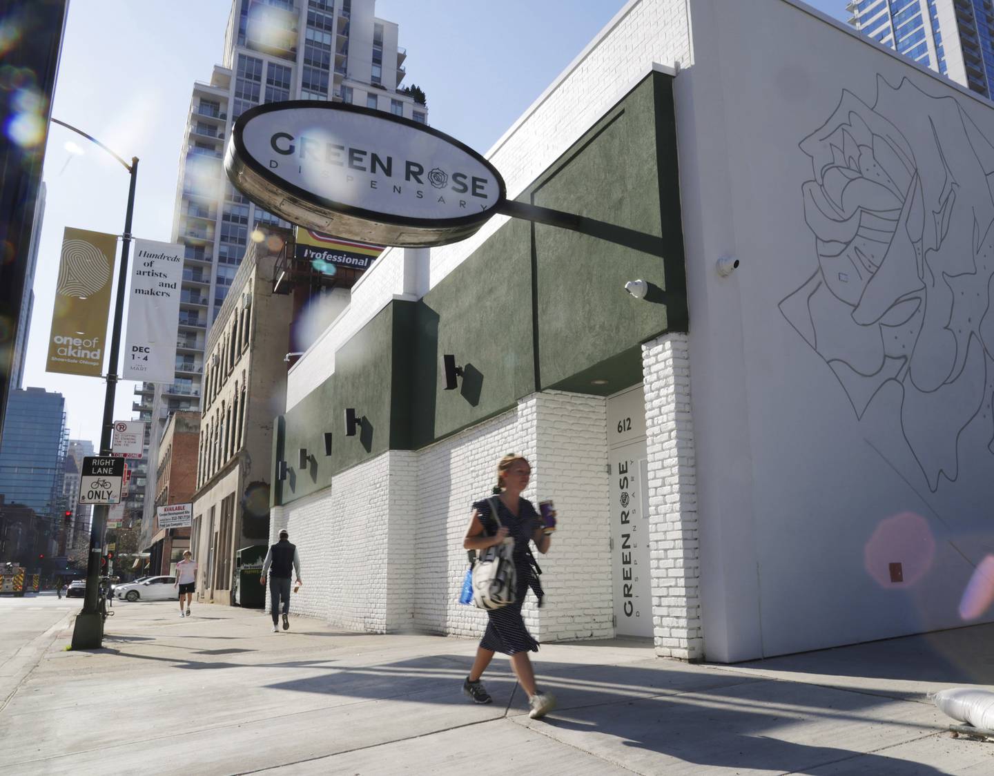 People pass by the Green Rose Dispensary along the 600 block of North Wells Street in Chicago on Nov. 10, 2022.